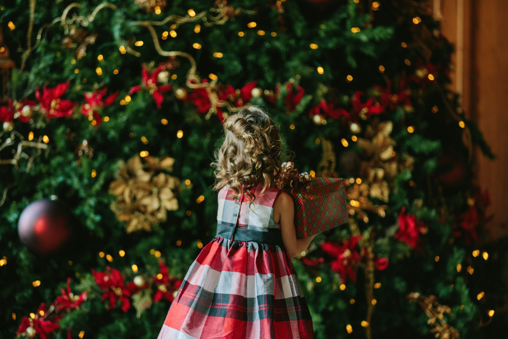 Little girl putting decorations on a Christmas tree