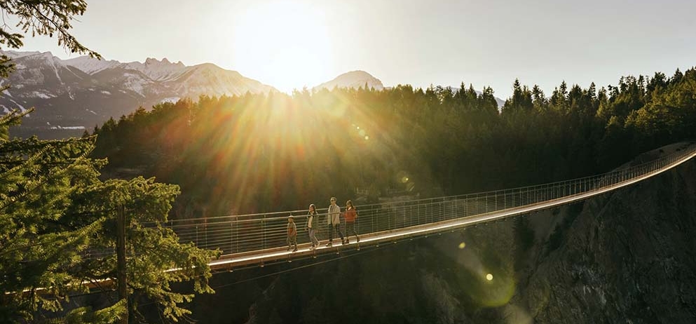 a family walking a cross a wooden bridge