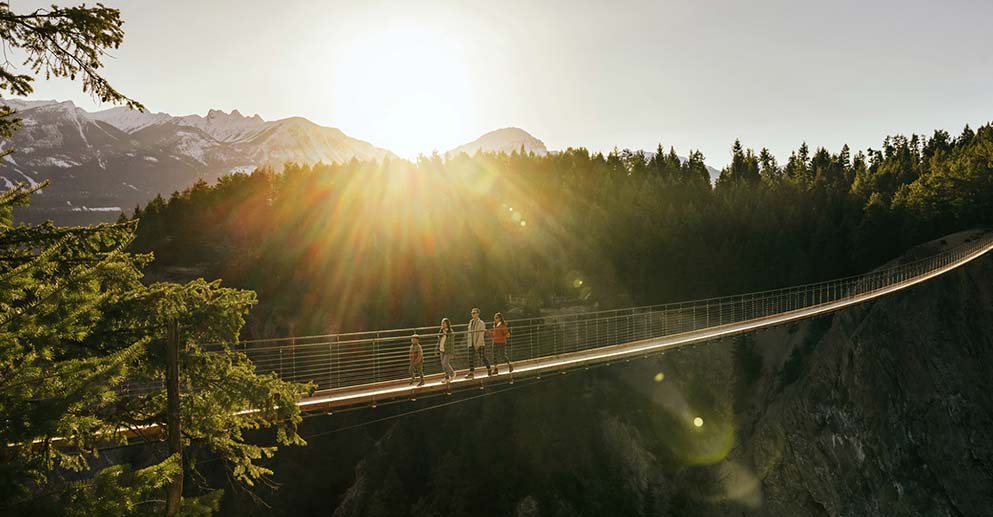 a family walking a cross a wooden bridge