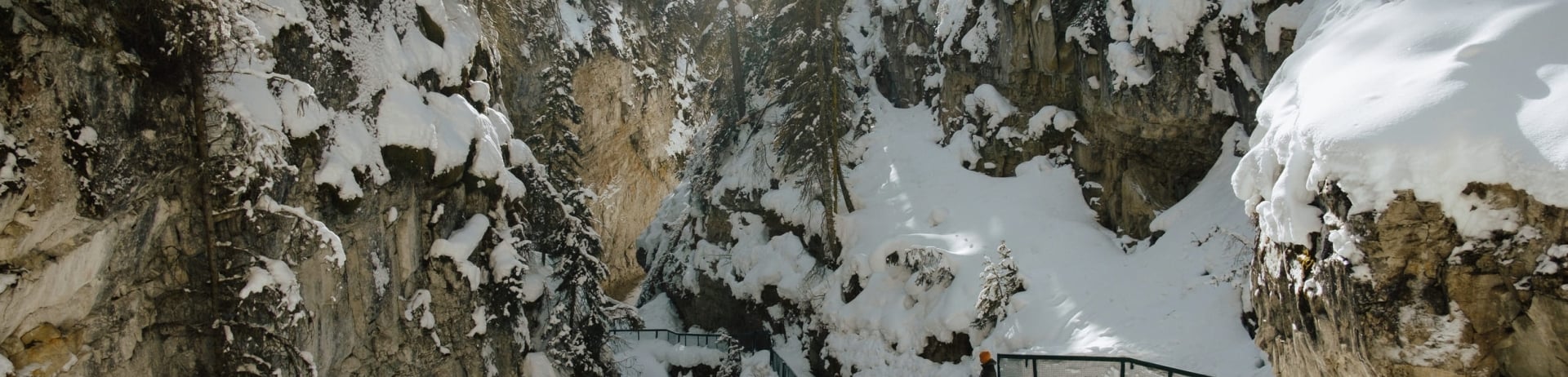 man walking along a trail at winter time