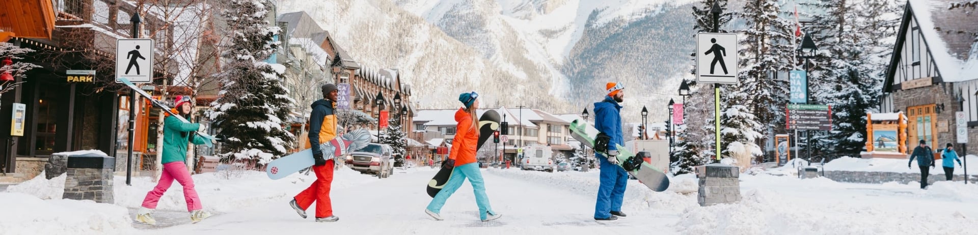people walking across the street with skis and snowboards