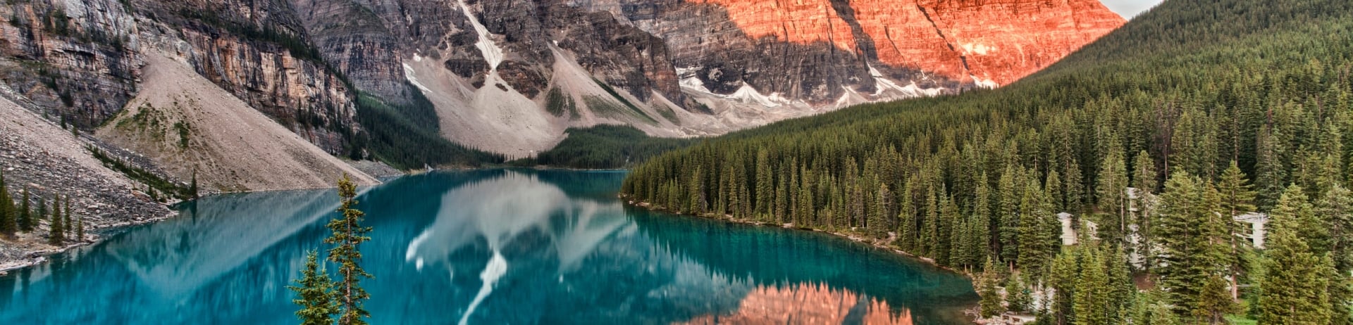 blue water lake surrounded by green trees and mountains