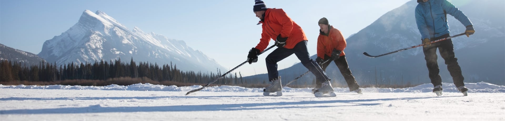 men playing hockey on a lake