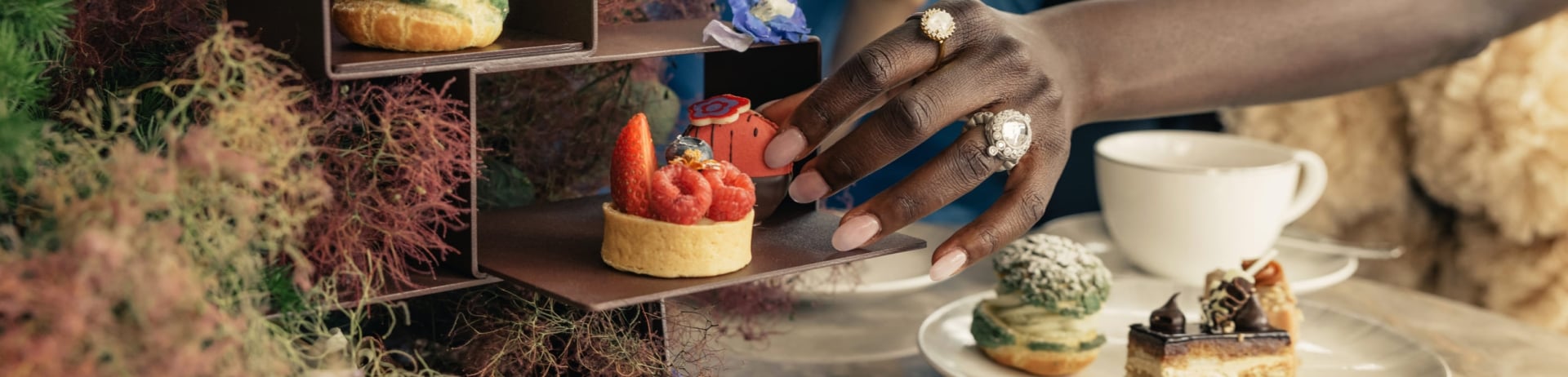 woman selecting a dessert at afternoon tea