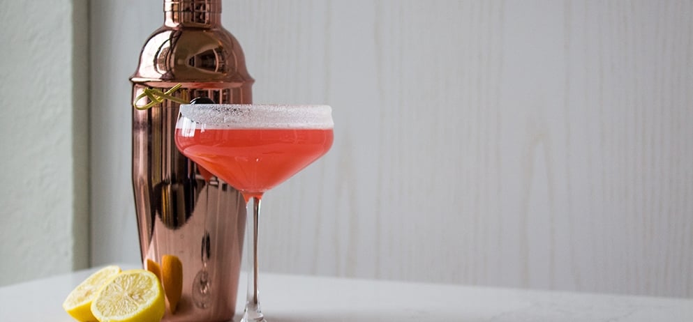 a red coloured drink in a coupe glass