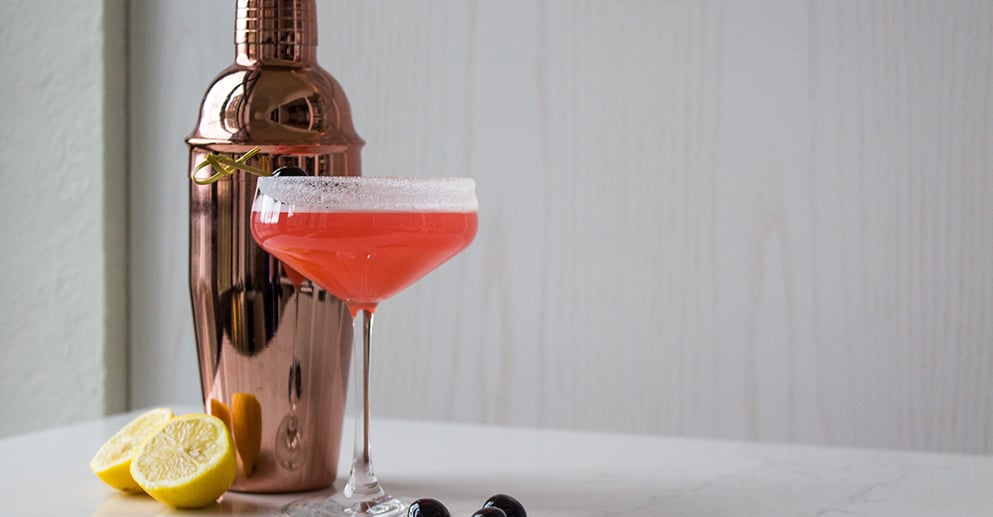 a red coloured drink in a coupe glass