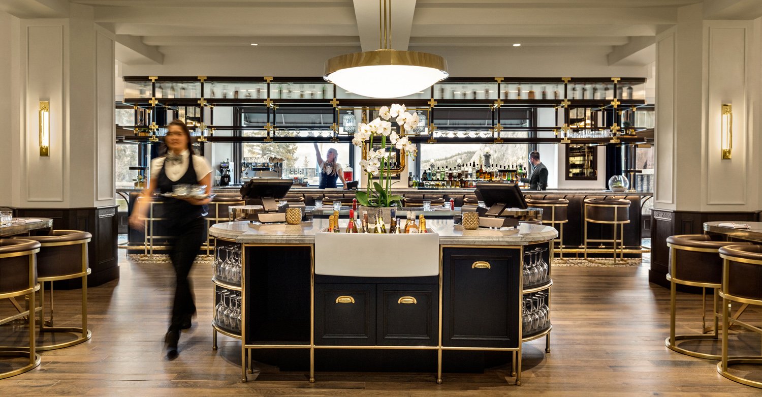 view of servers behind bar and walking through restaurant area