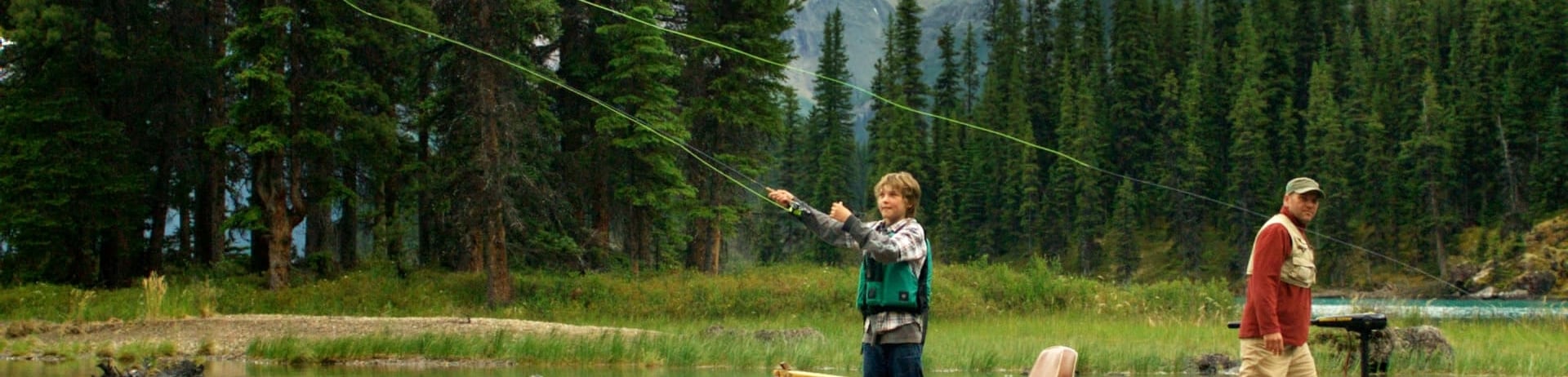 a father and sun fly fishing from a canoe