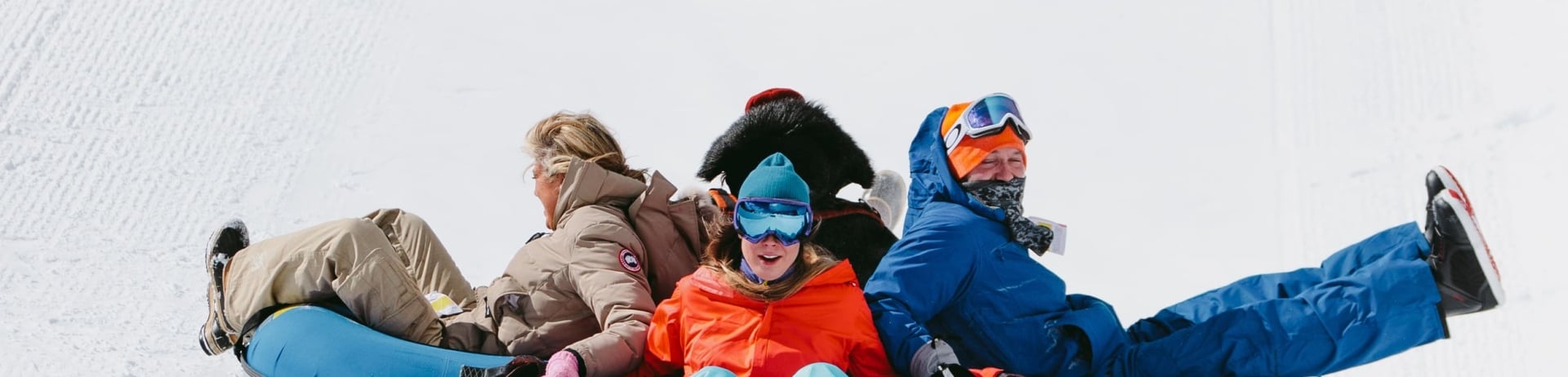 a family tubing down a steep hill