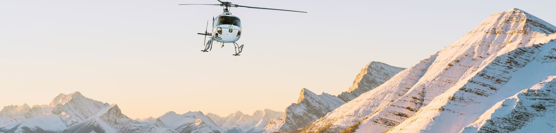 a helicopter flying over the mountains