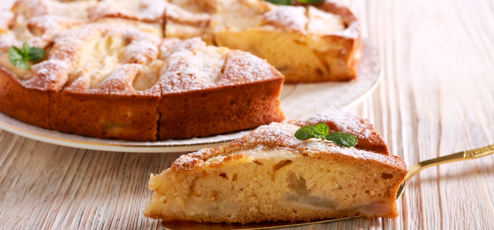 Fruit cake with icing sugar on top, served on plate