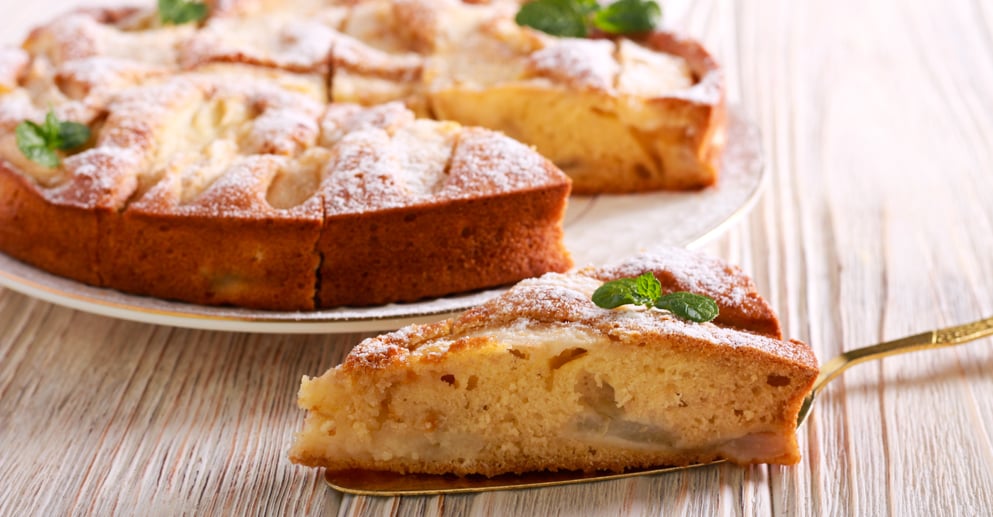 Fruit cake with icing sugar on top, served on plate