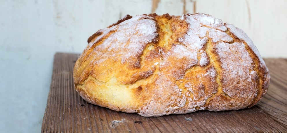 Loaf of bread on old wooden board.