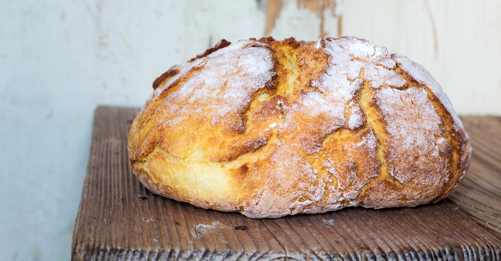 Loaf of bread on old wooden board.