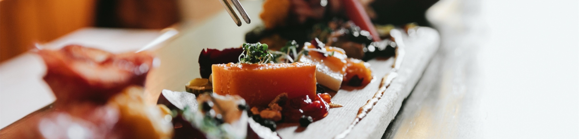 person selecting an item from a charcuterie board
