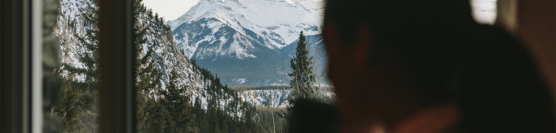 woman sipping coffee and looking out into the mountains