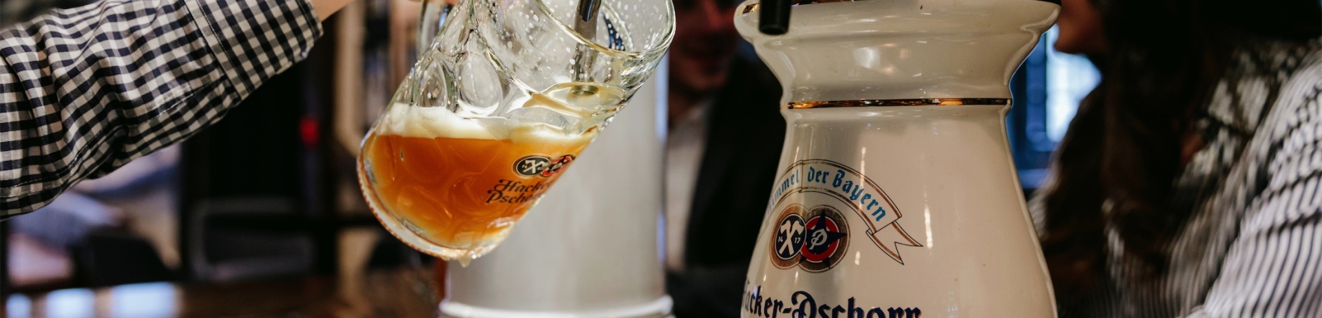 woman pouring beer into a steiner