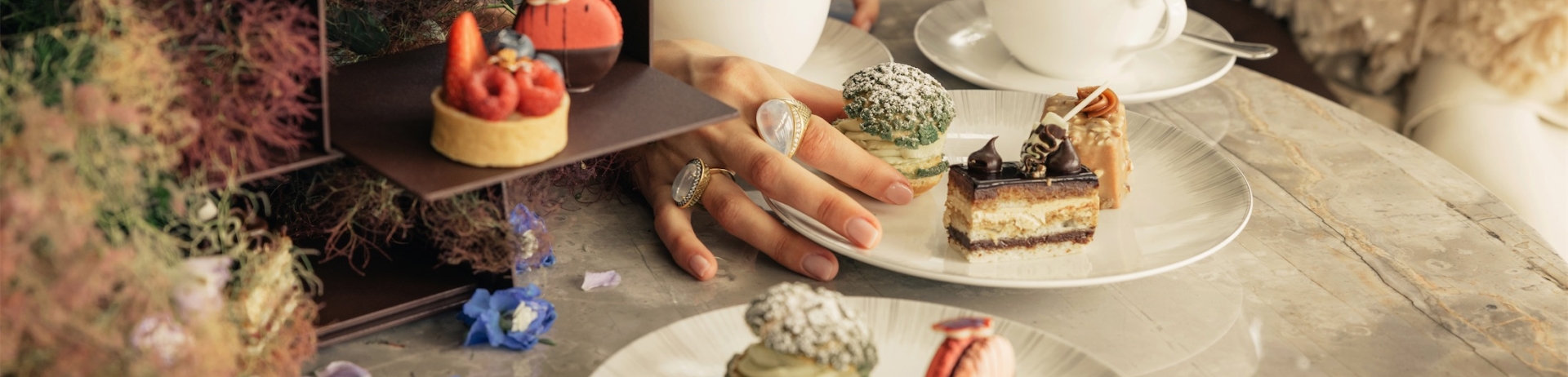 two women drinking tea and eating desserts