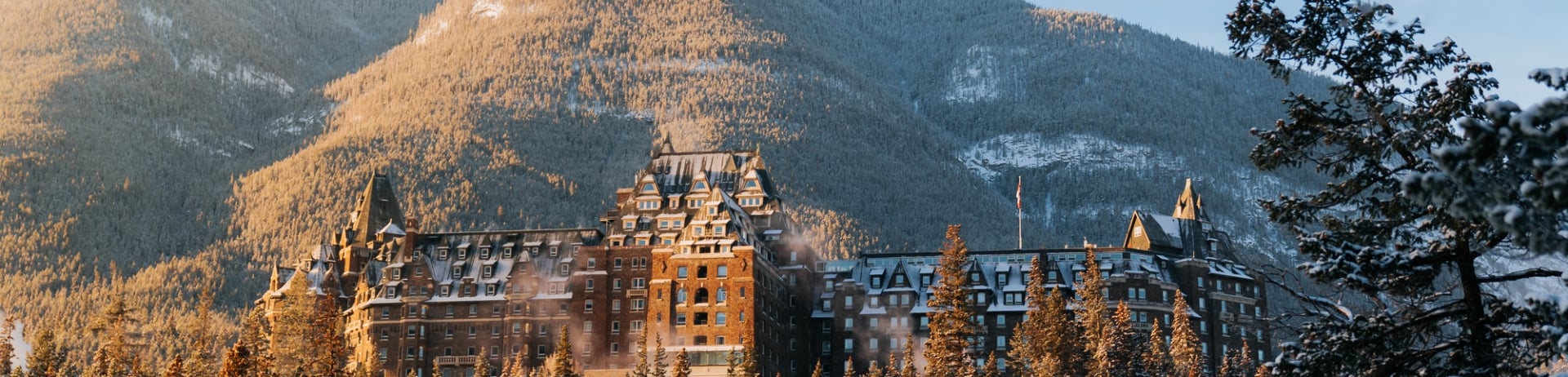 Landscape shot of the Fairmont Banff Springs in Banff; surrounded by trees and Sulphur Mountain behind.