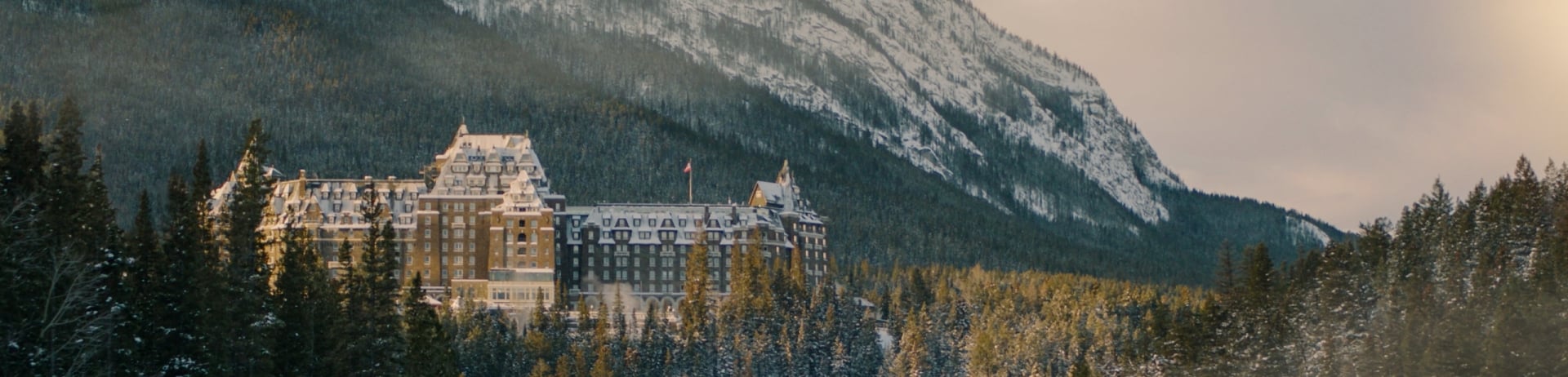 Landscape shot of the Fairmont Banff Springs in Banff; surrounded by trees and Sulphur Mountain behind.