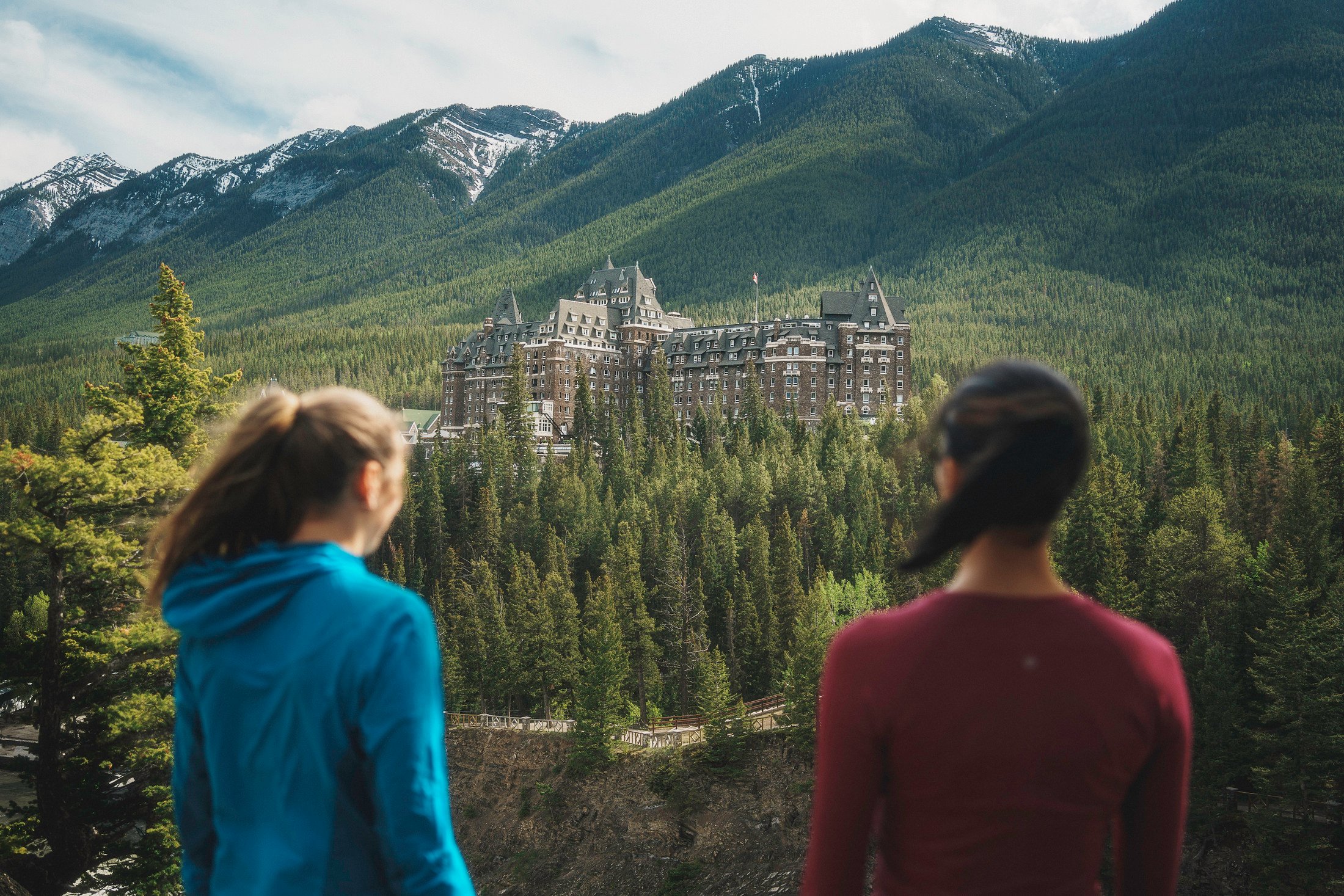 two women looking at a river and the Fairmont Banff Springs in the mountains
