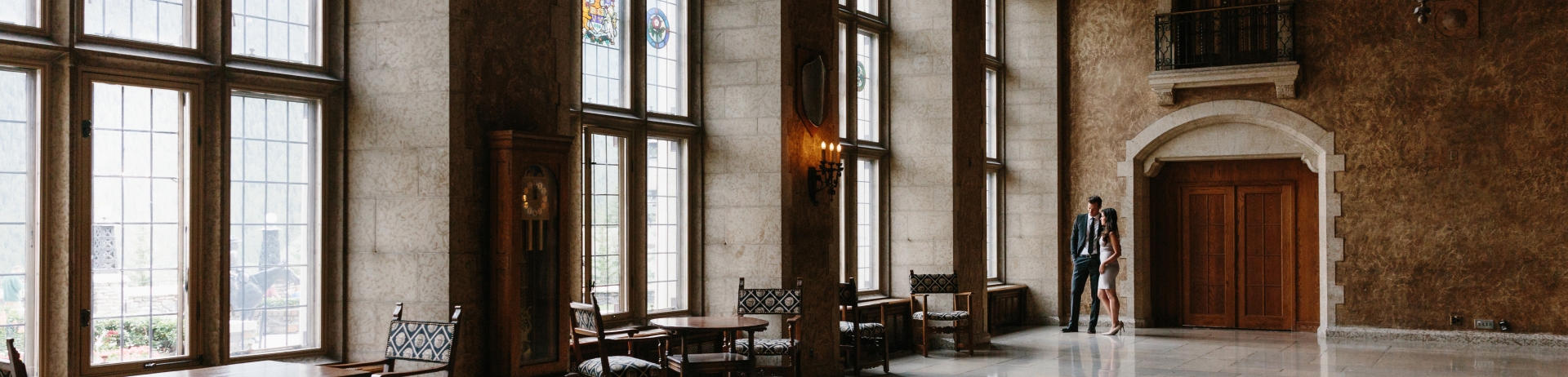 2 people standing in a grand hall.